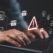 Warning alert icon with a hacked document system.Man typing on a keyboard with a red cybersecurity threat alert, surrounded by digital files and documents.