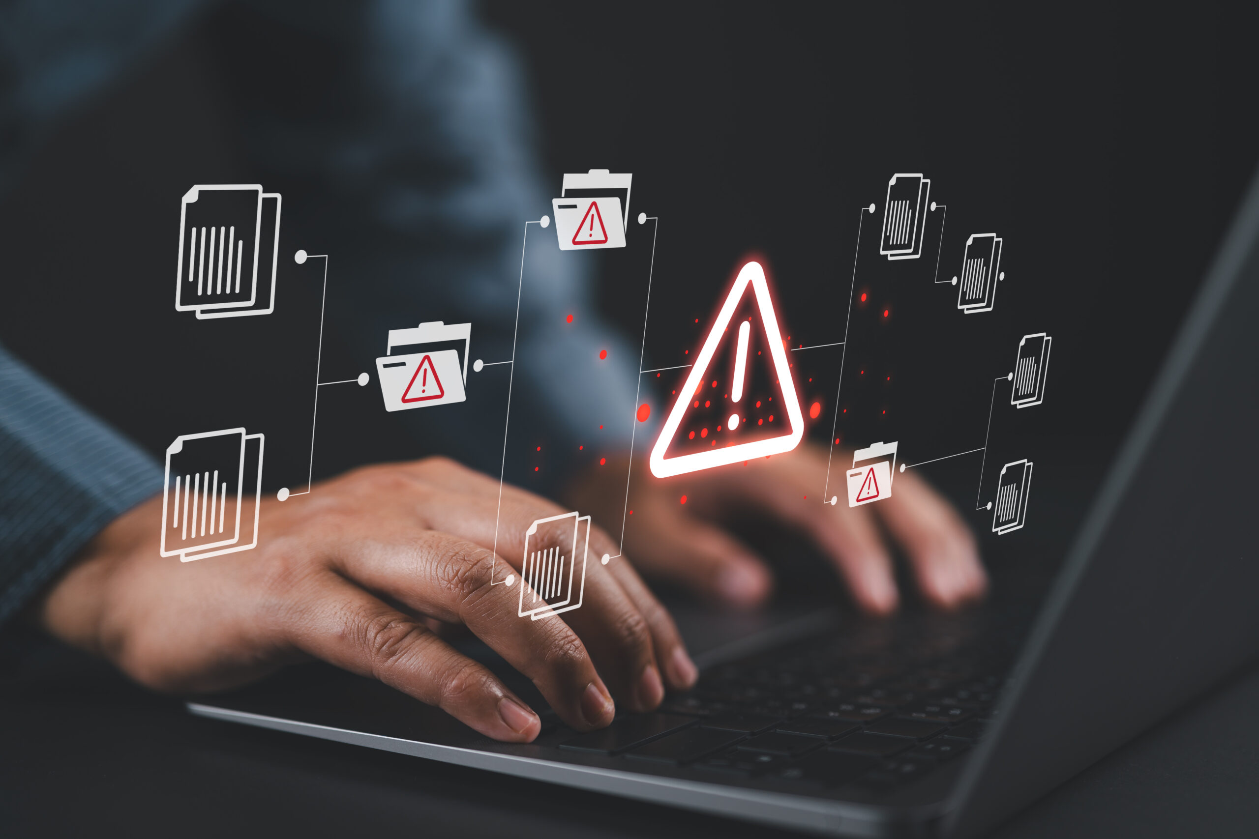 Warning alert icon with a hacked document system.Man typing on a keyboard with a red cybersecurity threat alert, surrounded by digital files and documents.